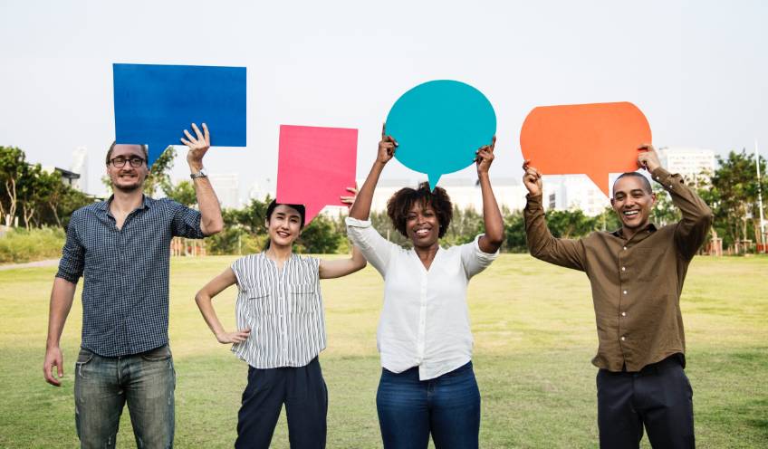 photo of people holding up chat bubbles representing multiple forms of fommunication